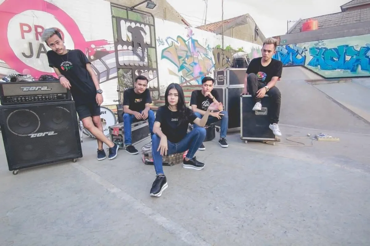 A five-piece band from the DWS Record roster posing at a graffiti-covered skate park